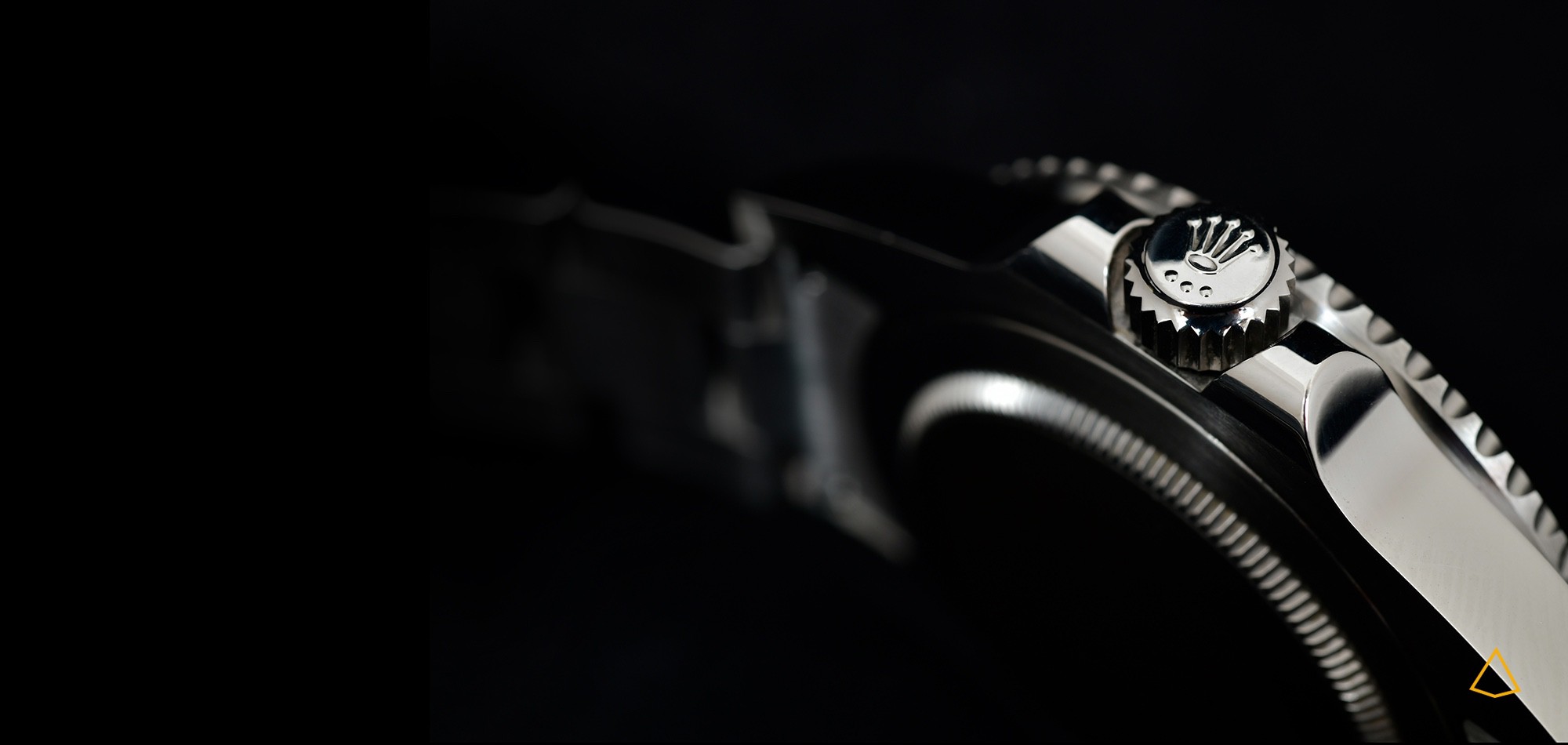 Dettaglio della cassa di un orologio Rolex su sfondo nero.